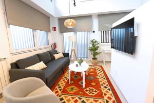 a living room with a couch and a table at Apartamentos Bahía&Arena - Centro in Santander