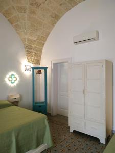 カザラーノにあるNinaneraのベッドルーム(緑のベッド1台、白いキャビネット付)