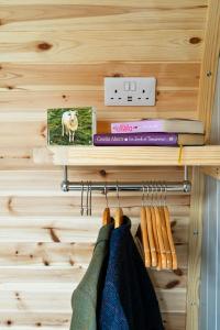 a shelf with books and hangers with clothes at Little Quarry Glamping Bed and Breakfast in Tonbridge