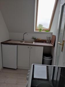 a kitchen with a sink and a window at Eider in Karolinenkoog