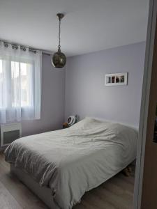 una camera bianca con un letto e una finestra di Maison individuel 500m JO a Vaires-sur-Marne