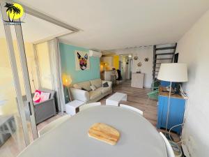 - un salon avec une table blanche et un canapé dans l'établissement T4 Le Trente Cinq 3 chambres & climatisation, au Cap d'Agde