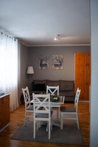 un soggiorno con tavolo, sedie e divano di Willa Marta M Sauna Jacuzzi a Zakopane