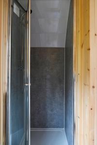 a shower with a glass door in a bathroom at Little Quarry Glamping Bed and Breakfast in Tonbridge