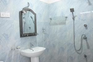 a bathroom with a sink and a shower with a mirror at Royal Inside Hotel in Udawalawe