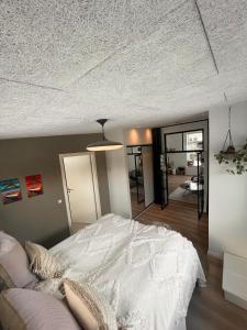 a bedroom with a white bed and a ceiling at Nyt hus fra 2022 med jungle vibe in Nørresundby
