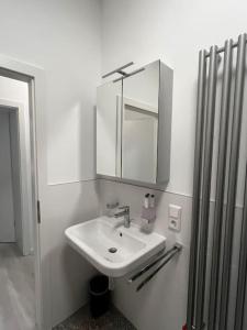 a white bathroom with a sink and a mirror at Lisboa: Messe/Business/FeWo DUS in Hilden