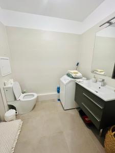 een witte badkamer met een toilet en een wastafel bij Dream Dwell Paris-Fantastic modern flat near RER A Paris in Saint-Maur-des-Fossés