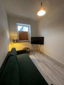 a living room with a couch and a flat screen tv at Lisboa: Messe/Business/FeWo DUS in Hilden