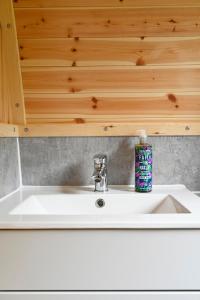 a white sink in a bathroom with a wooden ceiling at Little Quarry Glamping Bed and Breakfast in Tonbridge
