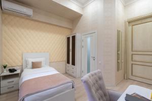 um quarto com uma cama, uma secretária e uma cadeira em Shoxjahon Hotel - 600 Mbps Internet em Tashkent