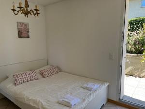a small bed in a room with a window at Individual house free parking wifi Netflix Disney next to EPFL Lausanne in Ecublens