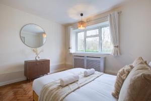 a bedroom with a bed and a mirror and a window at Artsy Serviced Apartments - Highgate in London