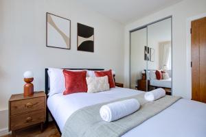 a bedroom with a large white bed with red pillows at Artsy Serviced Apartments - Highgate in London