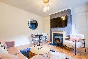a living room with a fireplace and a table at Artsy Serviced Apartments - Highgate in London