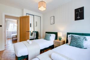 a bedroom with two beds and a couch at Artsy Serviced Apartments - Highgate in London