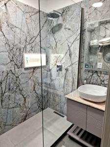 a bathroom with a sink and a shower at Aparthotel Shkodra in Durrës