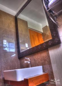 Siball Hotel في Abancay: حمام مع حوض ومرآة