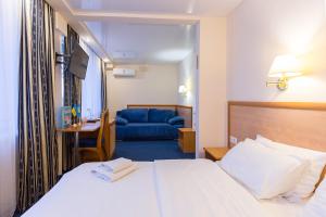 Truskavets 365 Hotel في تريسكوفيتس: غرفة فندق بسرير واريكة زرقاء
