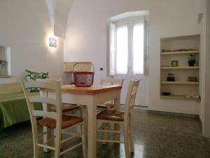 uma cozinha com uma mesa e quatro cadeiras em Ninanera em Casarano
