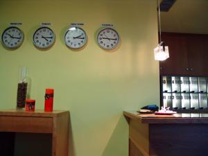 four clocks are on the wall in a room at Buenavista in Cuenca