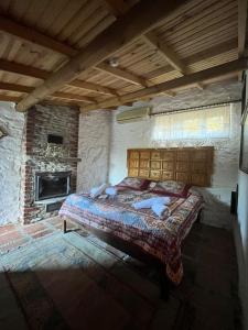 1 dormitorio con 1 cama en una habitación de piedra con chimenea en ŞİRİNCE BAHÇE OTEL en Selcuk