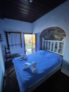 Un dormitorio con una cama azul con toallas. en ŞİRİNCE BAHÇE OTEL en Selcuk