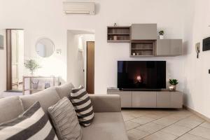 uma sala de estar com um sofá e uma televisão em Il Lauro - by MyHomeInComo em Como