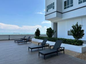 een rij stoelen aan de zijkant van een gebouw bij Amber Cove -Sunset Bliss Retreat Sea/CityView By Luxpro in Melaka