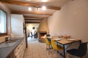 cocina y comedor con mesa y chimenea en La hantelle, en Saint-Hilaire-des-Landes