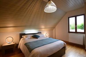 Saint-Hilaire-des-LandesにあるLa hantelleのベッドルーム1室(大型ベッド1台、ランプ2つ付)