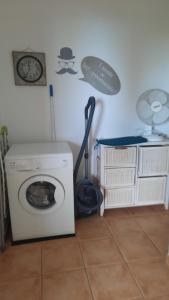ein Zimmer mit einer Waschmaschine und einer Uhr an der Wand in der Unterkunft un ecrin de verdure face à la mer in Isolaccio-di-Fiumorbo