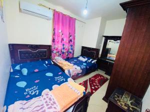 a bedroom with two beds and a mirror at فيلا دوبلكس في لاسيرينا السخنة in Ain Sokhna