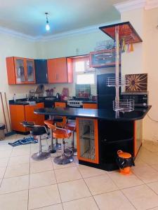 a kitchen with a black counter and stools in it at فيلا دوبلكس في لاسيرينا السخنة in Ain Sokhna