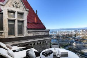 a building with a balcony with a view of a harbor at Château d'Ouchy in Lausanne