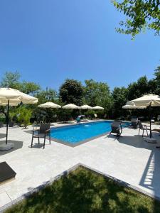 a swimming pool with chairs and umbrellas at Timeless Kartepe in Kartepe