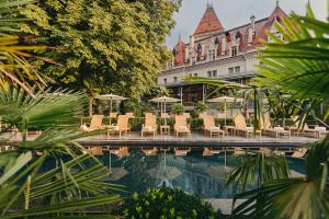 a pool with chairs and umbrellas in front of a building at Château d'Ouchy in Lausanne