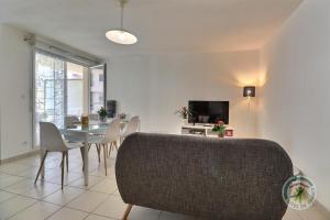 Un comedor con mesa y sillas y un televisor. en Le balcon de sevigne, en Cesson-Sévigné 11 fotos más