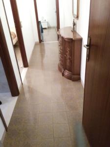 a hallway with a tile floor and a wooden door at Costa degli Etruschi in San Vincenzo