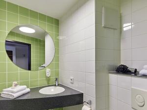 a bathroom with a sink and a mirror at B&B Hotel Osnabrück in Osnabrück