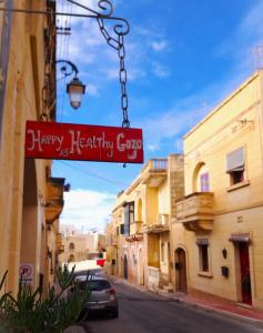 a sign for a happy healthy gng on a street at Happy and Healthy Gozo B&B HOUSE in Victoria