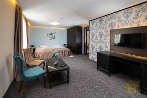 um quarto de hotel com uma cama e uma televisão de ecrã plano em Wellness Hotel Bulgaria em Bansko