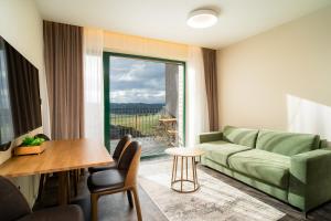 un soggiorno con divano e tavolo di Royal Village - Royal Views apartments a Malý Slavkov