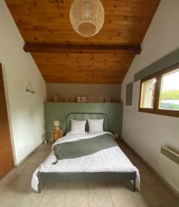 um quarto com uma cama e um tecto em madeira em Gîte de la Borderie em Saint-Silvain-sous-Toulx