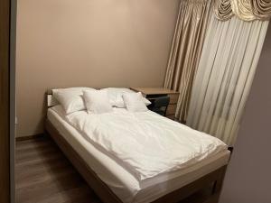 a bed with white sheets and pillows in a room at VIP Apartments Wrocław Iwaszkiewicza. in Wrocław