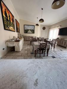 a dining room with tables and chairs and a tv at B&B Il Mandorlo in San Vito