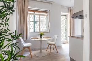 a white room with a table and chairs and a plant at Marchese 25 Apartments in Bari