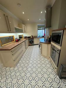 a large kitchen with a tile floor at Lovely home with a river view in Mytholmroyd