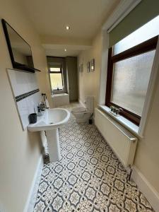 a bathroom with a sink and a toilet and a window at Lovely home with a river view in Mytholmroyd