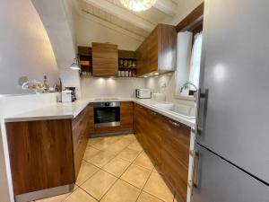 uma cozinha com armários de madeira e um frigorífico em Villa Fyllosia em Archanes